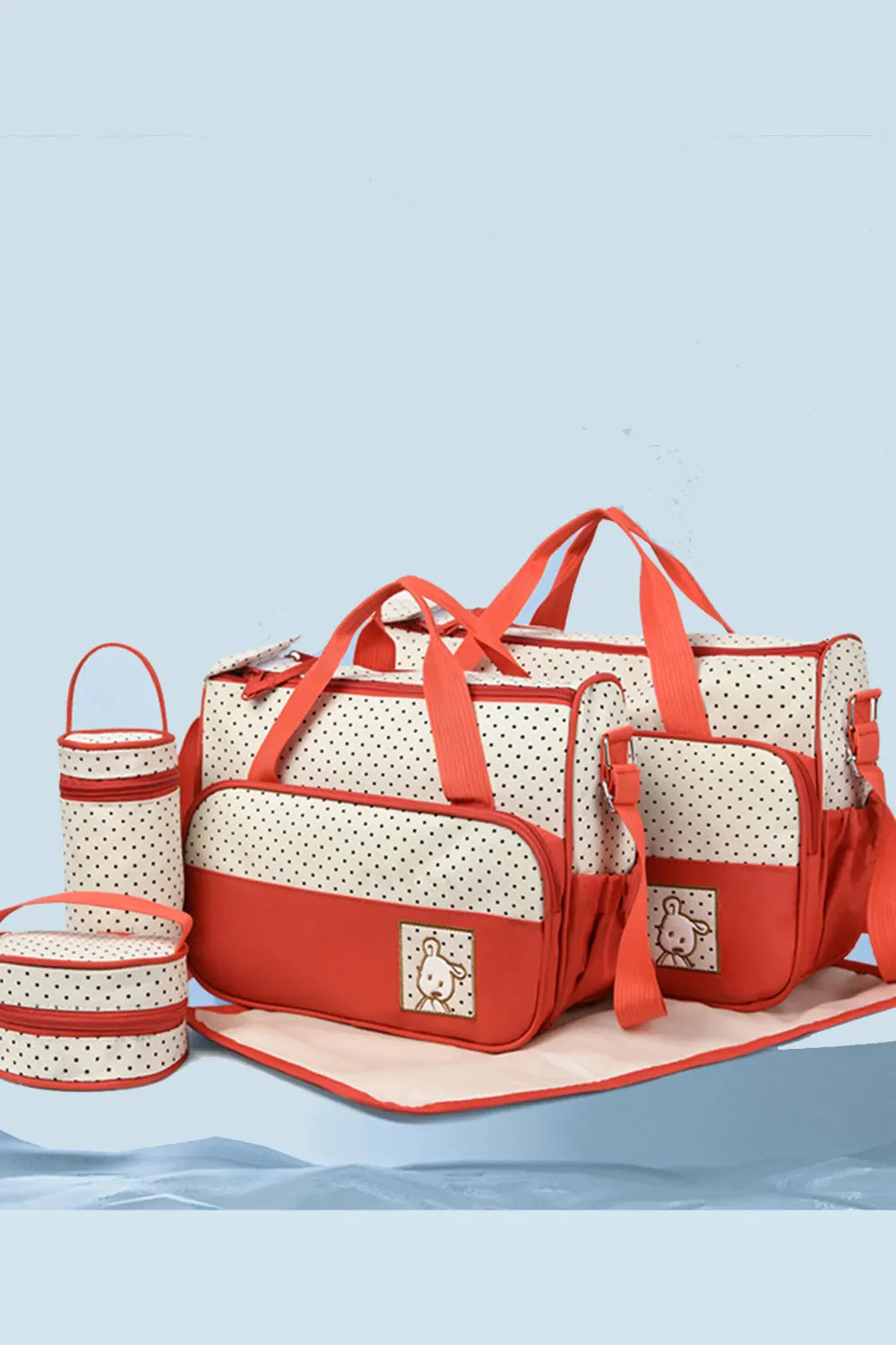 Red and cream polka dot diaper bag set with matching accessories and embroidered animal detail.