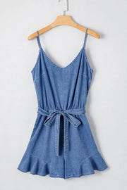 Medium denim romper with spaghetti straps, tie waist, and ruffled hem.
