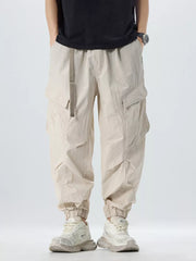 Oversized khaki cargo pants with adjustable belt and cinched ankles.