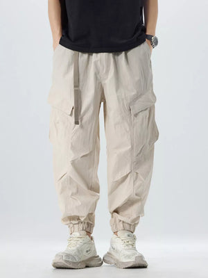 Oversized khaki cargo pants with adjustable belt and cinched ankles.