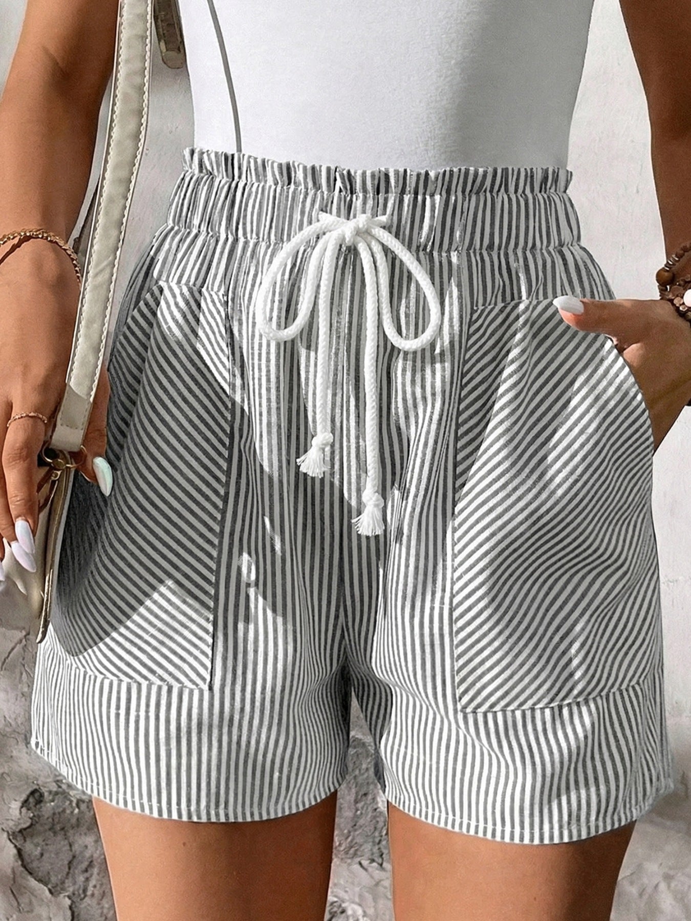 Gray and white striped cotton shorts with elastic drawstring waist and pockets.