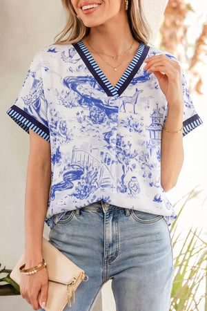Blue and white toile print v-neck blouse with striped accents and short sleeves.
