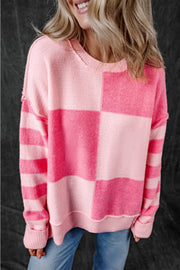 Checkerboard knit crewneck sweater in blush pink with striped sleeves.