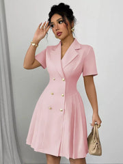 Blush pink double-breasted pleated blazer dress with gold buttons and short sleeves.