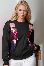 Black crewneck sweater with sequin nutcracker embellishments.