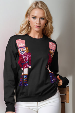 Black crewneck sweater with sequin nutcracker embellishments.