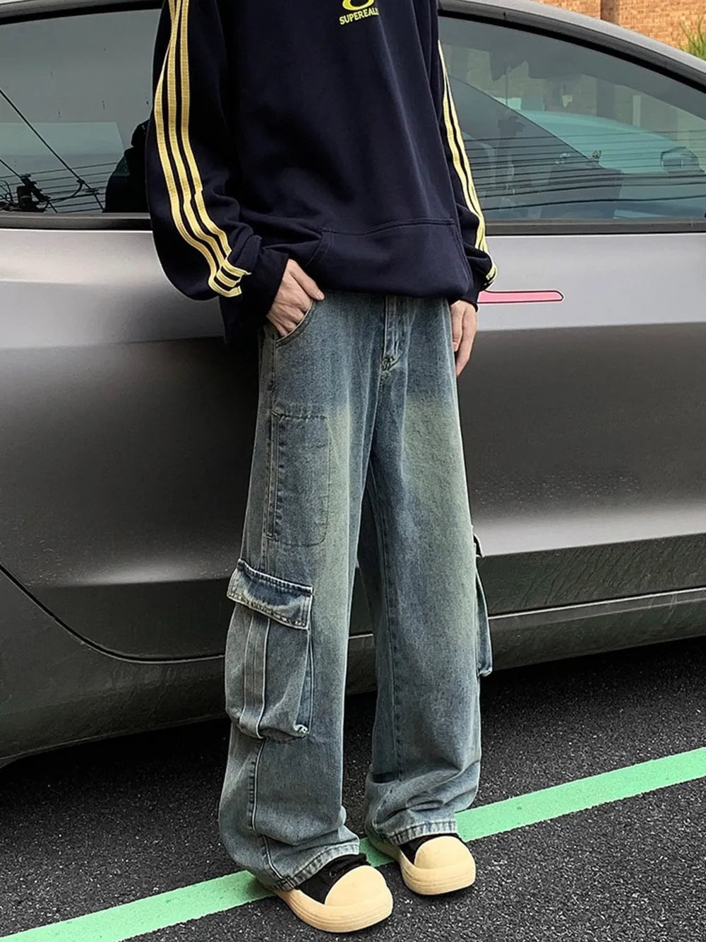 Men's vintage wash oversized wide leg cargo jeans with distressed detailing and large side pockets.
