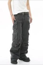 Baggy dark wash denim cargo pants with multiple pleated pockets and a silver grommet belt.