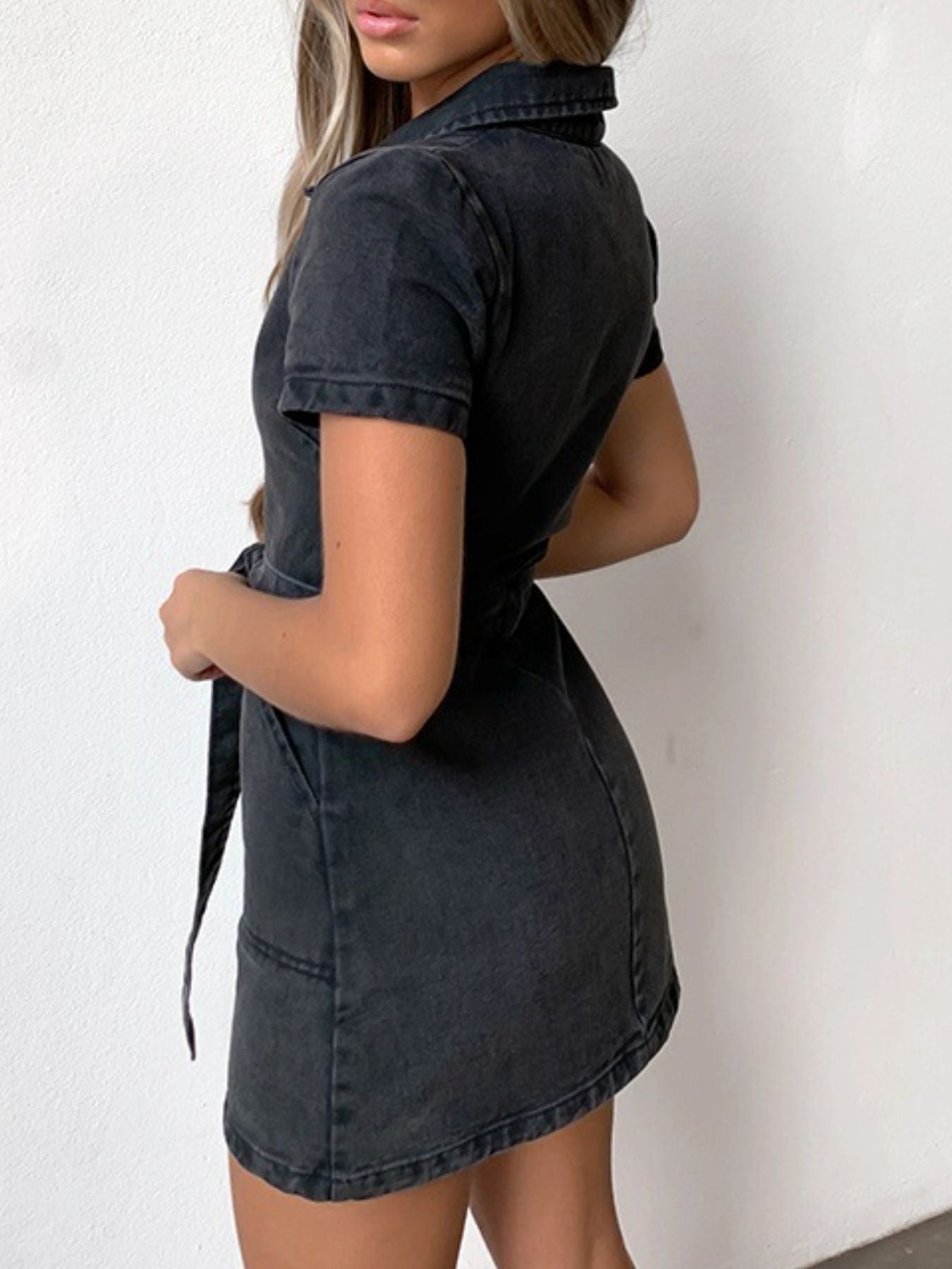 Zipper front denim mini dress in dark gray with short sleeves, collared neckline, and belted waist.