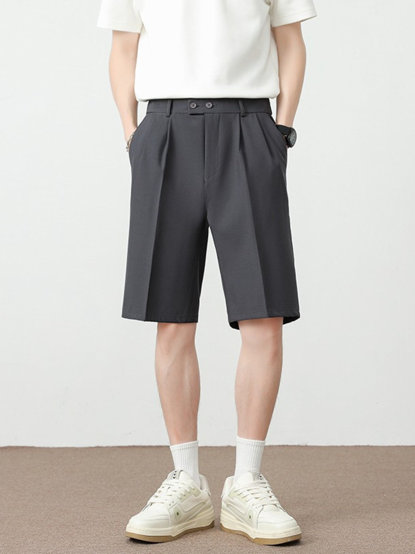 Men's dark gray pleated detail loose-fit chino shorts with a double button closure.