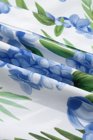 White blouse with blue hydrangea floral print and green leaves, V-neck detail.