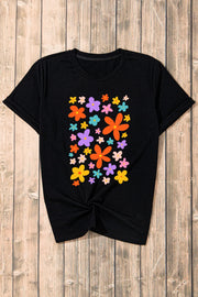 Black round neck tee with a colorful bloom print and twisted hem.