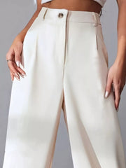 High-waisted apricot pleated wide-leg maternity trousers with button closure and pockets.