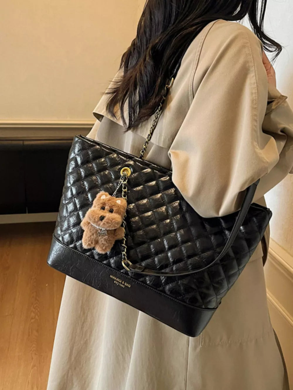 Luxurious quilted black shoulder bag with chain strap and teddy bear charm