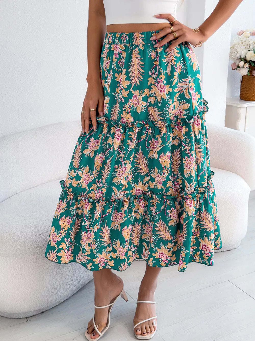 Green floral midi skirt with tiered ruffles and a ruffled hem.