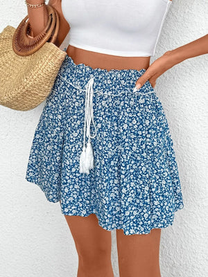 Light blue ditsy floral mini skirt with ruffled hem and drawstring waist with tassels.