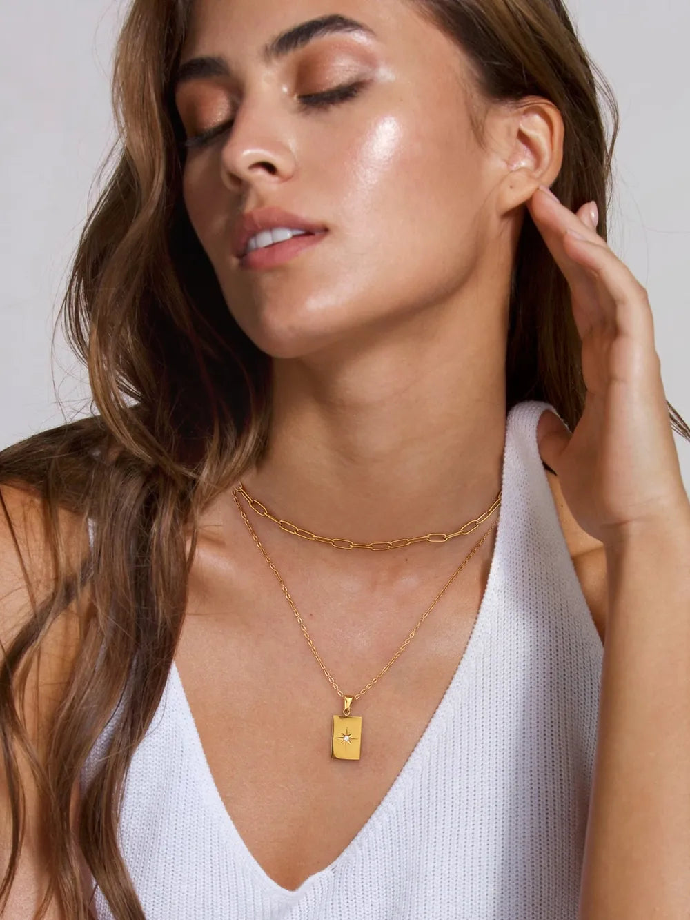 Gold celestial pendant layered chain necklace with delicate chain detail.
