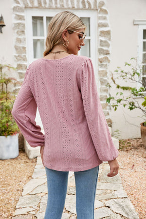 Dusty pink eyelet yoke blouse with blouson sleeves and textured fabric.