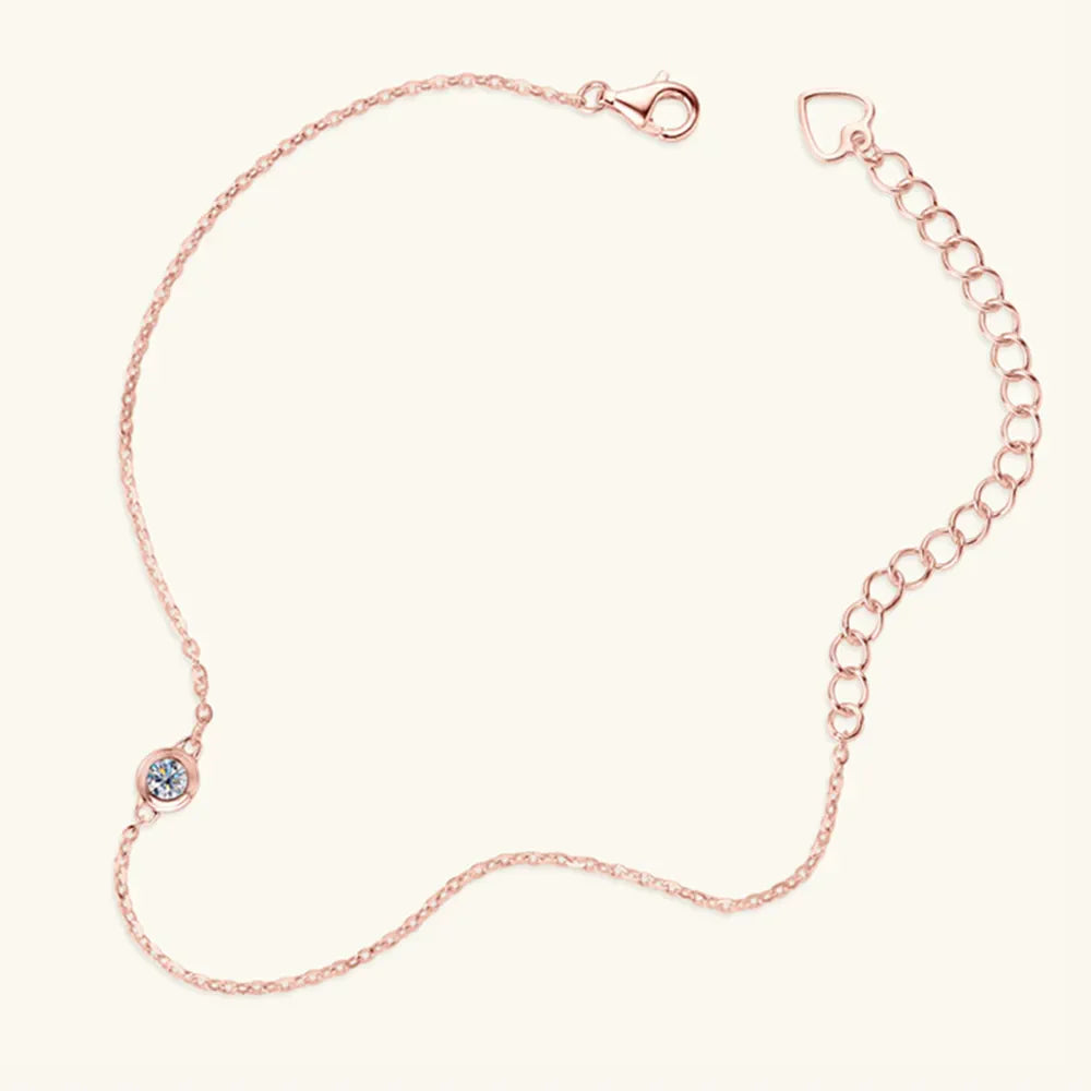 Rose gold chain bracelet with a single moissanite solitaire and heart charm extender.