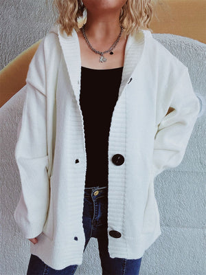 White chunky knit hooded button-down cardigan with large dark buttons and pockets.