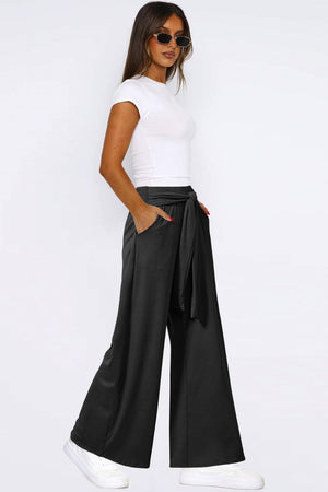 Black palazzo trousers with tie waist and wide leg, styled with a white top.