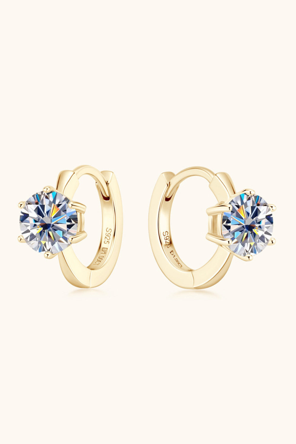 Gold moissanite solitaire huggie hoop earrings with clear round-cut stones.
