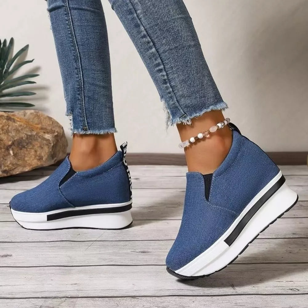 Blue slip-on platform shoes with round toe and chunky white sole.
