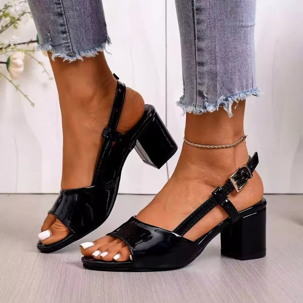 Black patent open-toe slingback block heels with ankle strap and buckle.