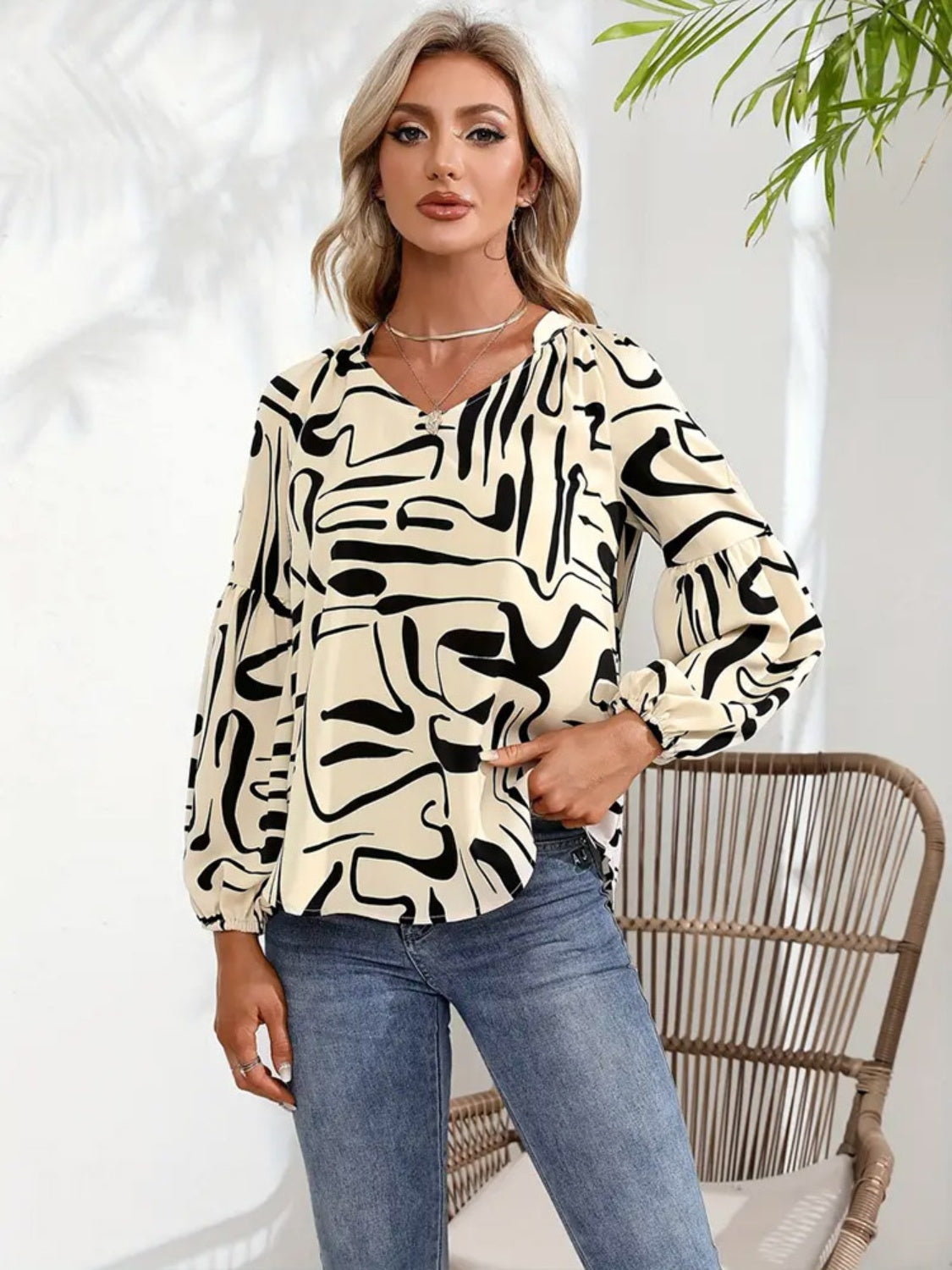 Women's cream top with abstract black scribble print and blouson sleeves.