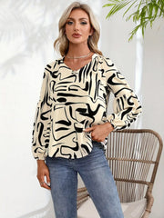 Women's cream top with abstract black scribble print and blouson sleeves.