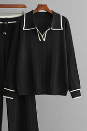 Black ribbed knit loungewear set with contrast trim on collar and cuffs.