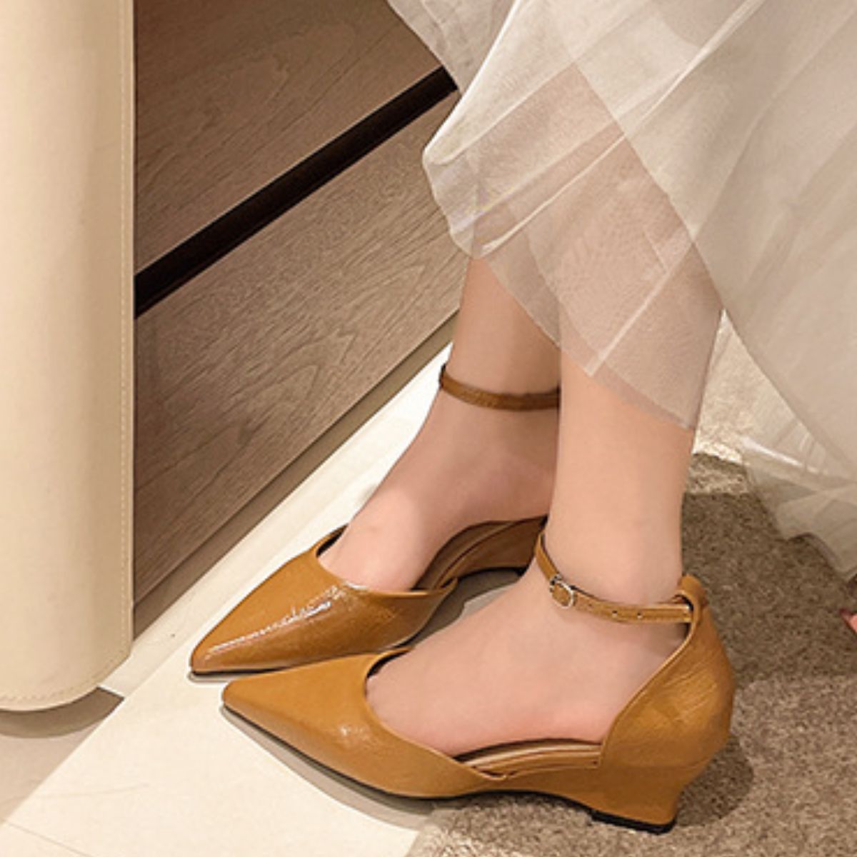 Brown pointed-toe ankle strap heels with adjustable buckle detail.