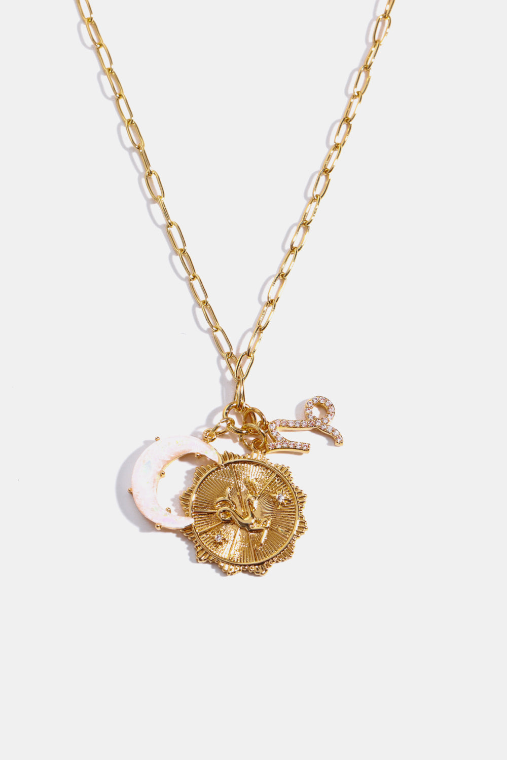 Gold celestial pendant necklace with zodiac charm, moon, and key.