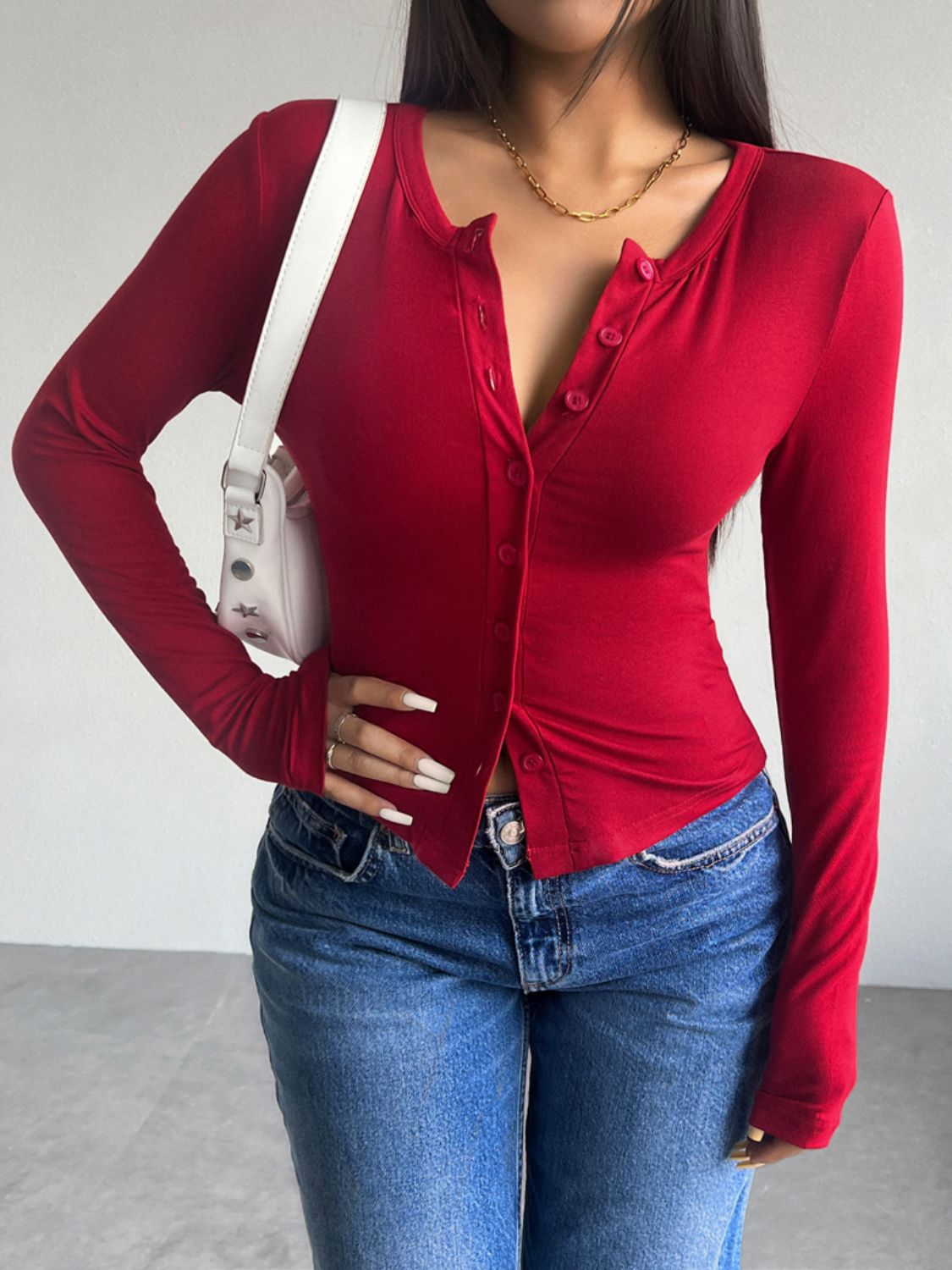 Scarlet button-up cardigan with a scoop neck and long sleeves, styled with jeans.
