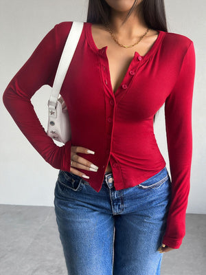 Scarlet button-up cardigan with a scoop neck and long sleeves, styled with jeans.