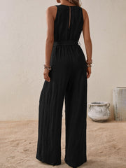 Black textured wrap-front wide-leg jumpsuit with belted waist and keyhole back.