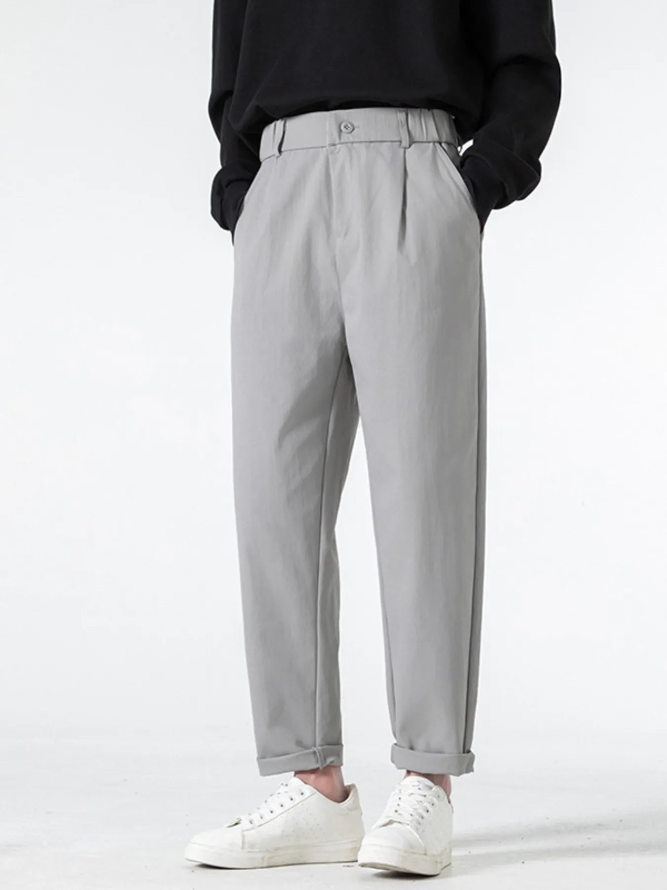 Grey casual pleated trousers with a loose fit and cuffed hems.