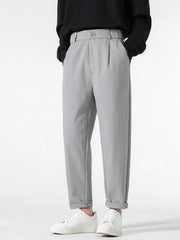 Grey casual pleated trousers with a loose fit and cuffed hems.