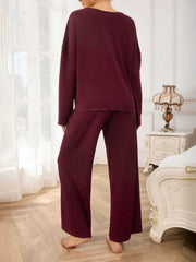 Burgundy textured loungewear set with wide-leg pants and long-sleeve top.