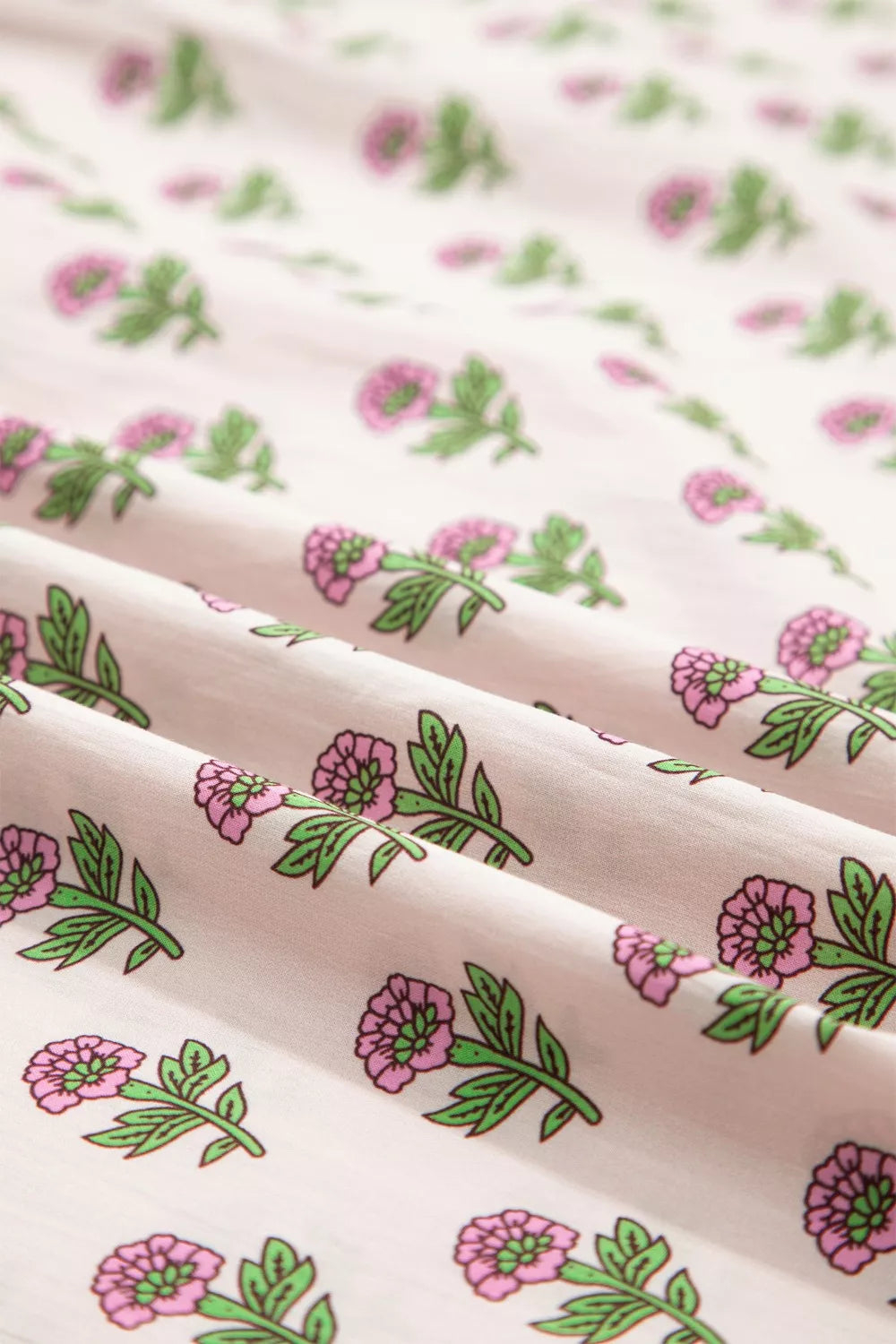 Floral V-neck midi dress in blush pink with a charming pink floral print and green leaves.