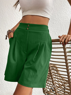 Pleated front bermuda shorts in dark green with button detail at the waist.
