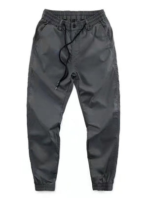 Men's grey drawstring joggers with a relaxed fit and cuffed ankles.