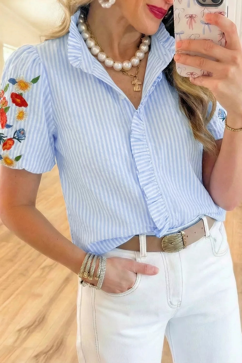 Blue striped cotton shirt with embroidered floral puff sleeves and frill detail.