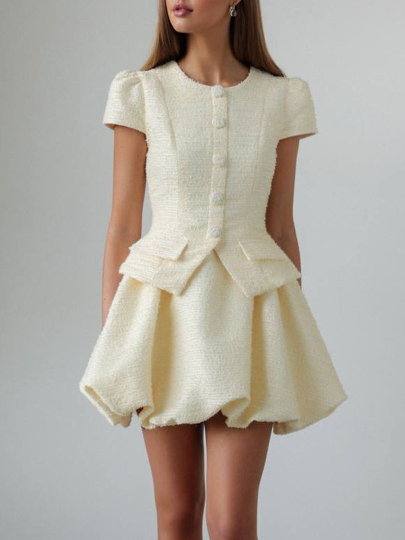 Textured cream button-down dress with short sleeves, peplum waist, and bubble hem skirt.
