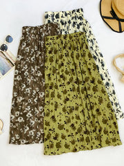 Botanical print midi skirts in black, tan, and olive with crinkled texture.