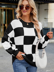 Checkerboard knit sweater in black and white with balloon sleeves and crew neck.
