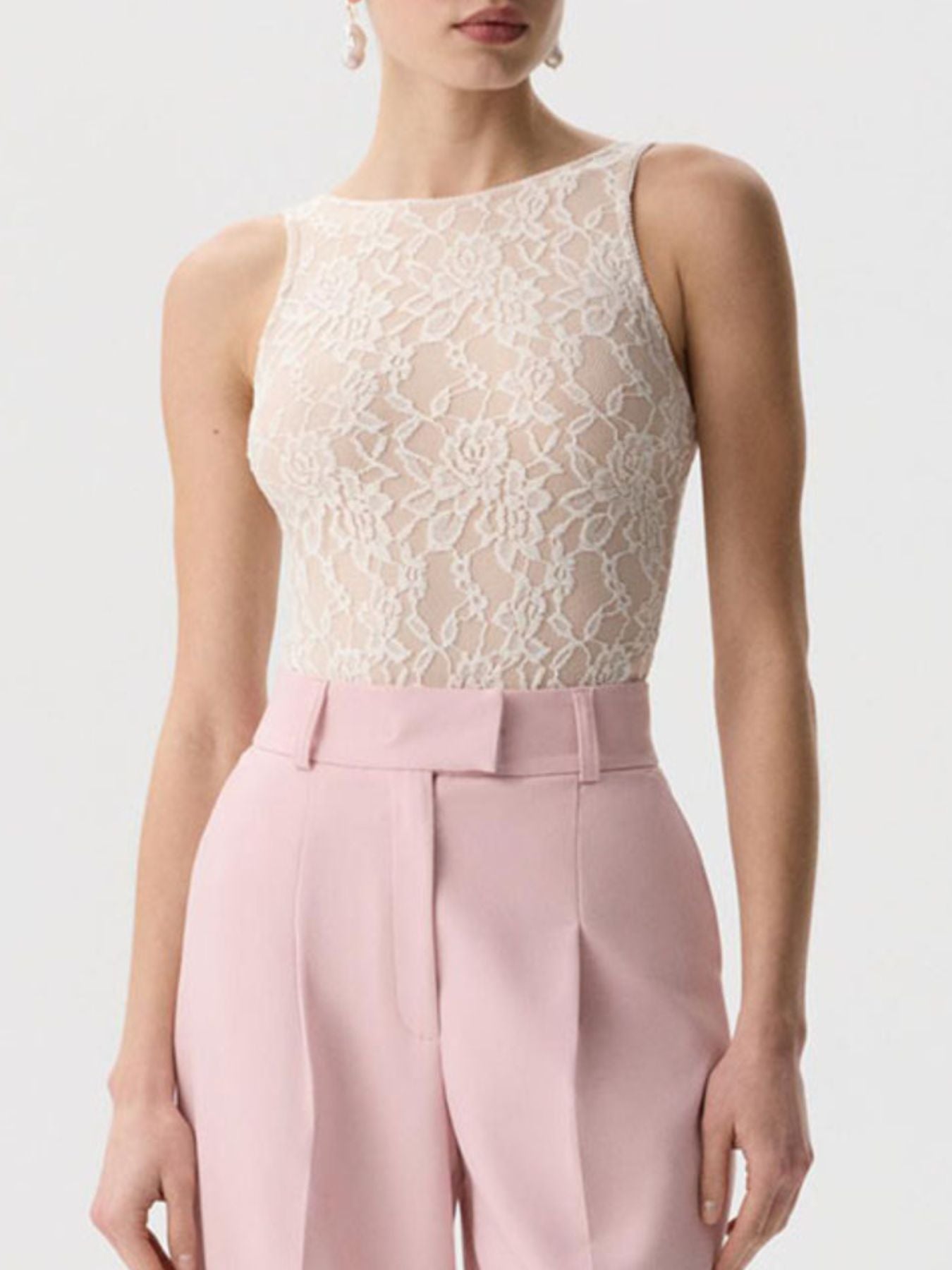 Sheer lace tank top in beige with floral pattern and round neckline.