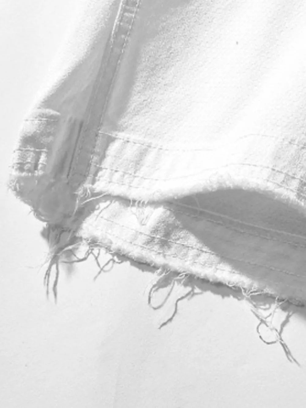 White men's cargo shorts detail with frayed hem and visible stitching.