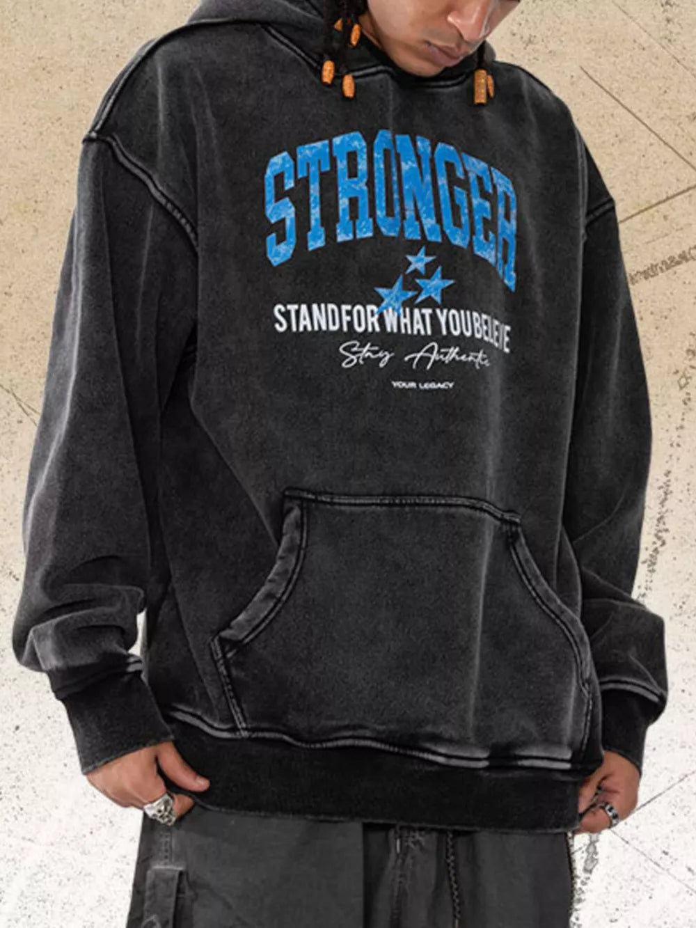 Charcoal faded graphic hoodie with blue "STRONGER" text and motivational design.