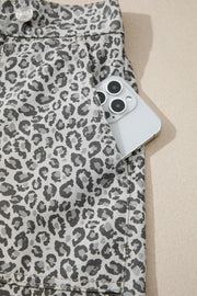Denim shorts with leopard print and a pocket holding a phone.